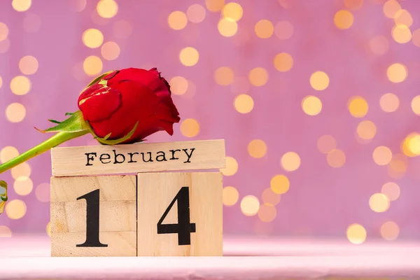Calendario de madera 14 de febrero sobre fondo rosa bokeh —  Fotos de Stock