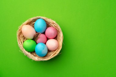 Yeşil arka planda bir yuvada paskalya yumurtaları
