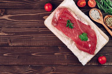 Kahverengi tahta üzerinde çiğ et filetosu.