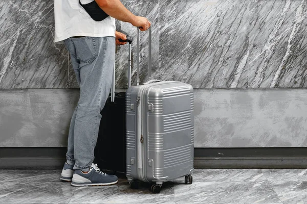 Hombre casual irreconocible de pie con maleta de equipaje —  Fotos de Stock