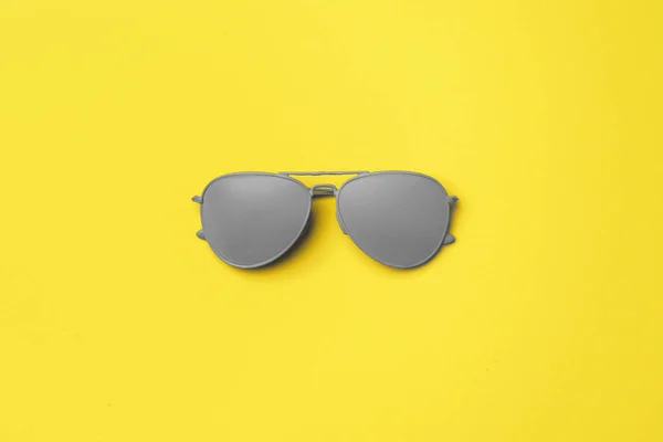 Серые солнечные очки на желтом фоне — стоковое фото