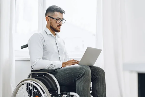 Empresario sentado en silla de ruedas y usando laptop — Foto de Stock