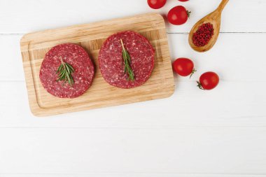 Tahtada iki çiğ hamburger köftesi.