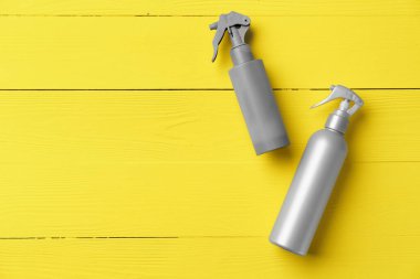 Sarı ahşap arka planda gri kozmetik şişesi