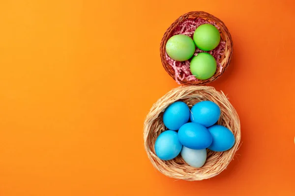 Huevos de Pascua en un nido sobre fondo naranja — Foto de Stock