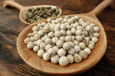 White peppercorn spice heap on wooden table clipart