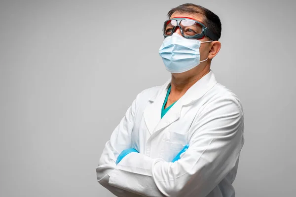 Seniorarzt mit Mundschutz vor grauem Hintergrund — Stockfoto