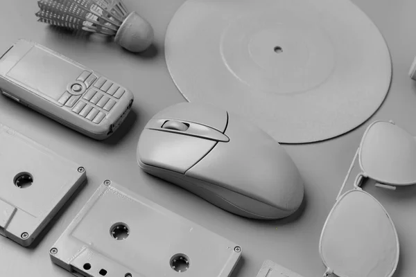 Graue Kassetten, Computermaus, Disc und Handy auf grauem Hintergrund — Stockfoto
