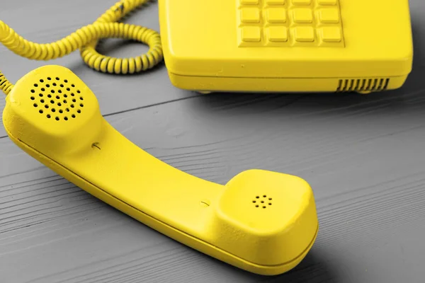 Żółty telefon stacjonarny na szarym tle widok z góry — Zdjęcie stockowe