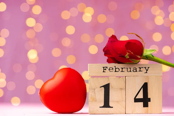 Calendario de madera 14 de febrero sobre fondo rosa bokeh —  Fotos de Stock