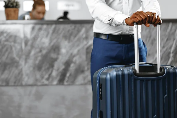 Pengusaha yang tidak dikenal berdiri dengan koper bagasi di lobi hotel — Stok Foto