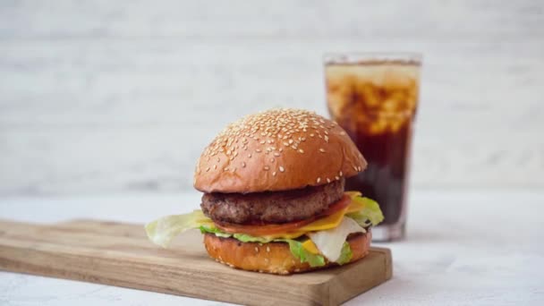 Färsk välsmakande burgare serveras med läsk och pommes frites på vitt bord — Stockvideo