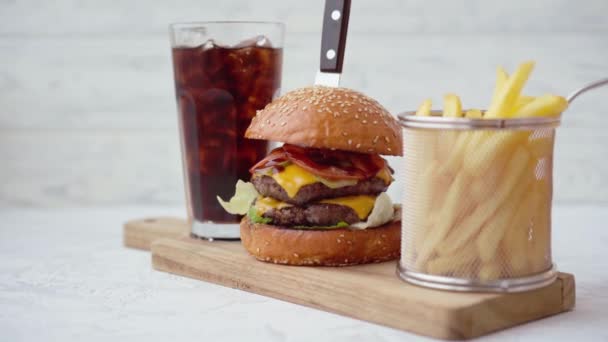 Friss, ízletes hamburger szódával és sült krumplival a fehér asztalon. — Stock videók