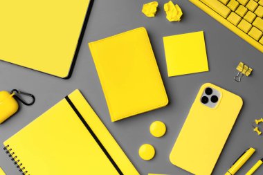 Gri arkaplan üzerinde akıllı telefon ve kalem olan sarı not defteri