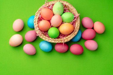 Yeşil arka planda bir yuvada paskalya yumurtaları