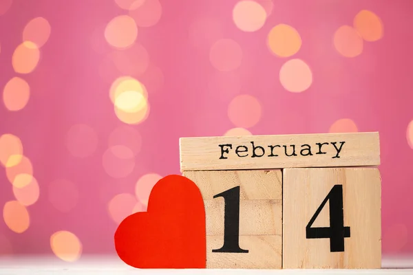 Dřevěný kalendář 14. února na růžové pozadí bokeh — Stock fotografie
