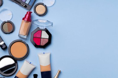 Cilt makyaj ürünleri ve mavi arkaplanda fırça