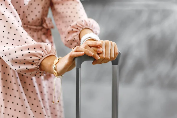 Mulher irreconhecível em vestido rosa de pé com mala de bagagem — Fotografia de Stock