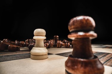 Siyah arkaplana karşı satranç taşlarıyla satranç oyunu