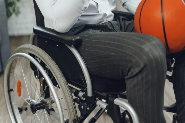 Joven discapacitado en silla de ruedas sosteniendo pelota de baloncesto — Foto de Stock