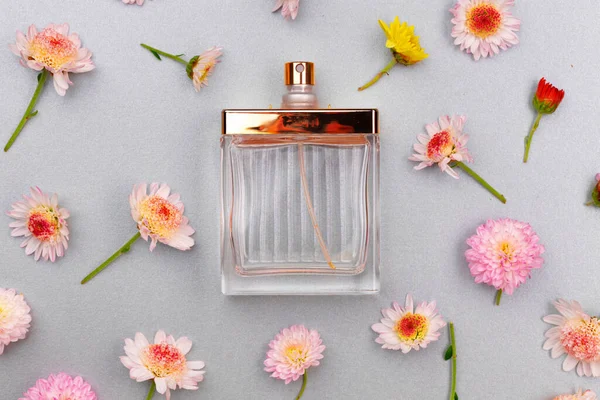 Bottle of fragrance surrounded by flower buds — Stock Photo, Image