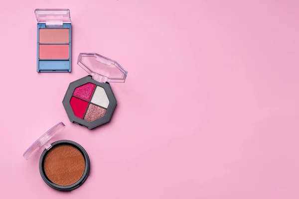 El juego de las sombras de ojos componen los productos sobre rosado — Foto de Stock