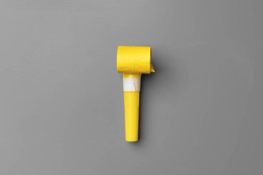 Gri arkaplan görünümünde sarı parti düdüğü