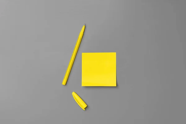 Yellow adhesive notes and pen on gray background — Stock Photo, Image