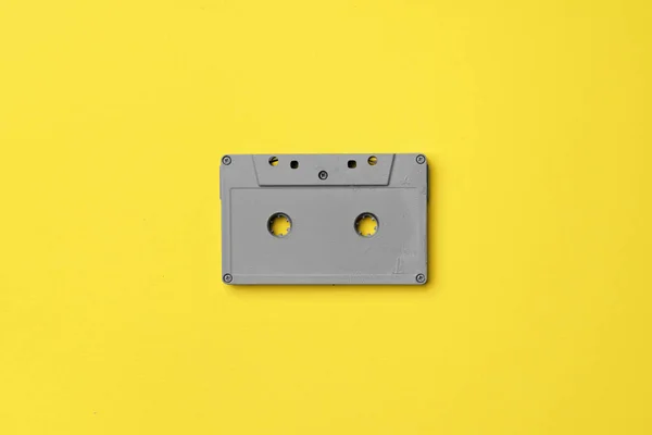 Graue Audiokassette auf gelbem Hintergrund von oben — Stockfoto