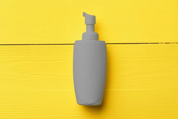黄色木制底座灰色化妆品瓶 — 图库照片