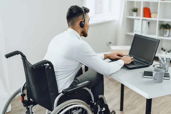 Hombre discapacitado en silla de ruedas usando laptop — Foto de Stock