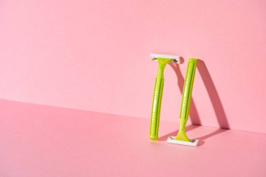 Pembe arka planda tek kullanımlık kadın jiletleri, stüdyo çekimi.