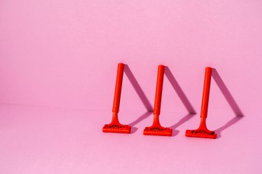 Pembe arka planda tek kullanımlık kırmızı jilet, kopyala alanı