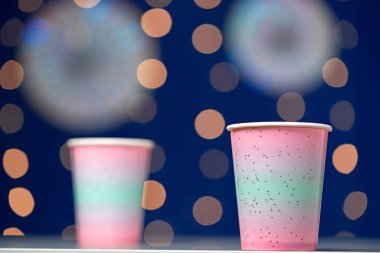 Mavi bokeh arkaplanda tek kullanımlık pembe bardaklar