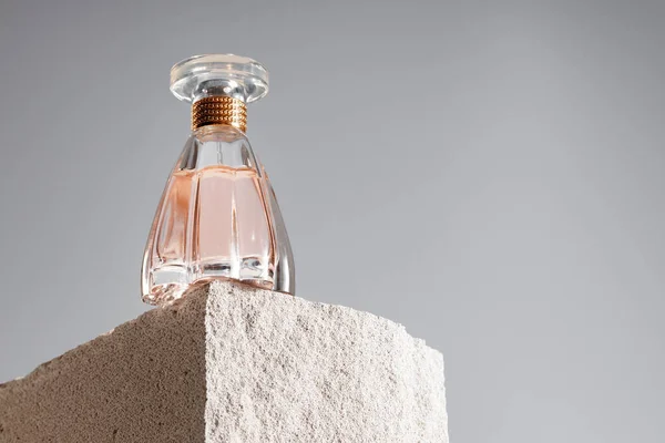 Frasco de fragrância transparente no bloco .cinder cinza — Fotografia de Stock