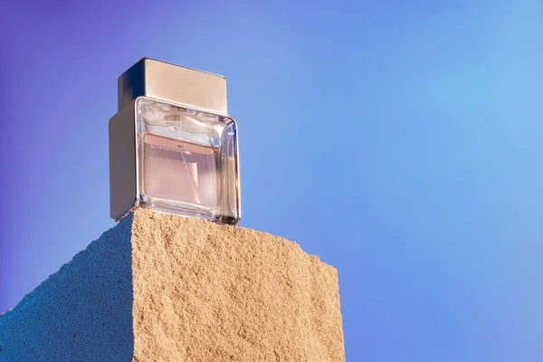 Transparent fragrance bottle on gray .cinder block — Stock Photo, Image