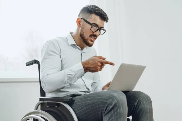 Empresario sentado en silla de ruedas y usando laptop — Foto de Stock