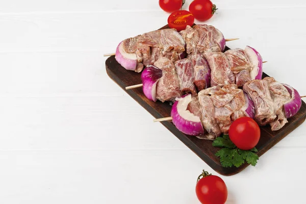 Raw marinated kebab on skewers on wooden background — Stock Photo, Image