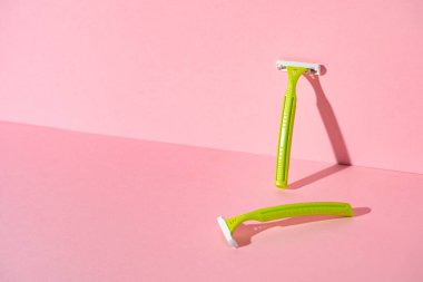 Pembe arka planda tek kullanımlık kadın jiletleri, stüdyo çekimi.