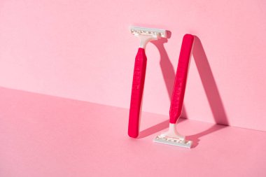 Pembe arka planda tek kullanımlık jiletler, kopyalama alanı