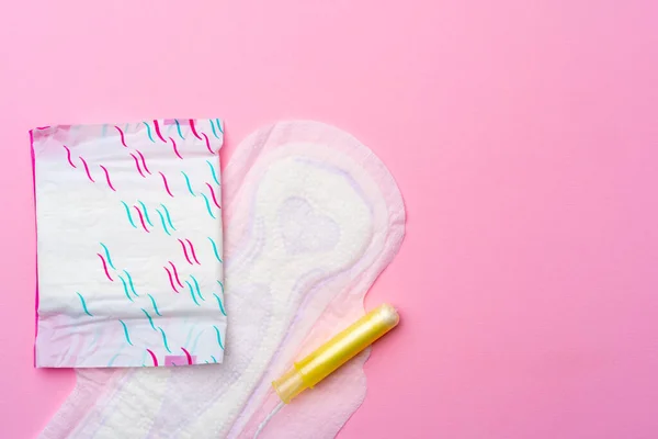 Женская гигиеническая прокладка и тампоны на розовом фоне — стоковое фото