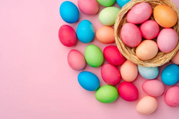 Ovos de Páscoa pintados em ninho decorativo em fundo rosa — Fotografia de Stock