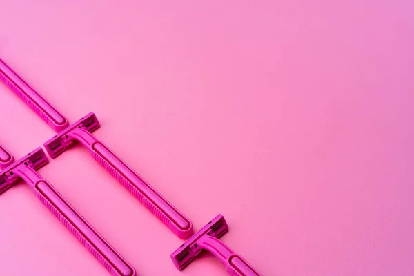 Rasoi monouso femminili su sfondo rosa vista dall'alto — Foto Stock
