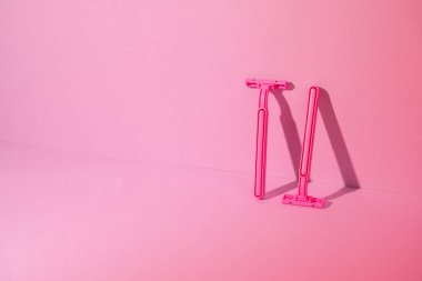 Pembe arka planda tek kullanımlık jiletler, kopyalama alanı