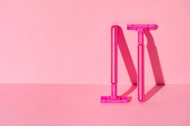 Pembe arka planda tek kullanımlık jiletler, kopyalama alanı