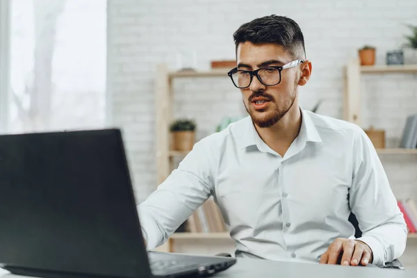 Junger erfolgreicher Geschäftsmann nutzt Laptop am Schreibtisch — Stockfoto