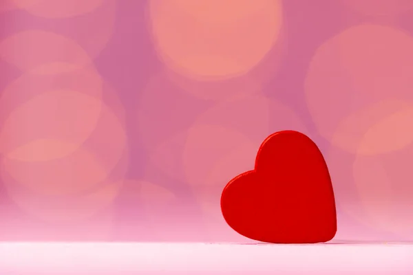 Decoración de corazón rojo contra fondo rosa bokeh — Foto de Stock