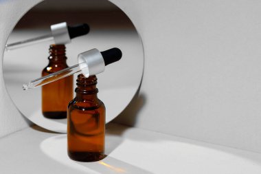 Cam kavanoz kozmetik yağı ve aynalı yaratıcı fotoğraf