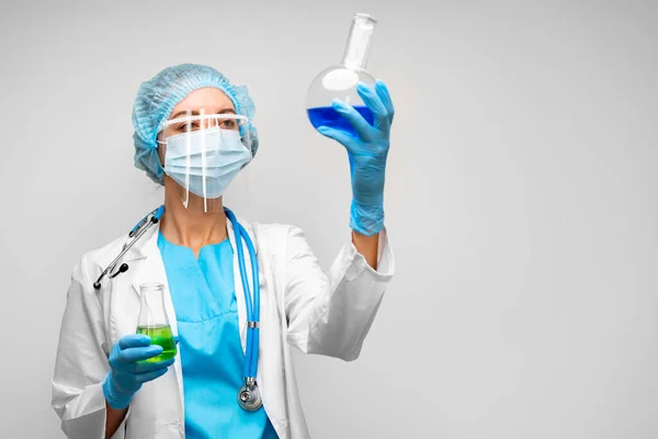 Mulher cientista segurando frasco de laboratório com líquido químico, fundo cinza — Fotografia de Stock