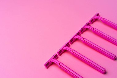 Pembe arka plan görünümünde tek kullanımlık kadın jiletleri